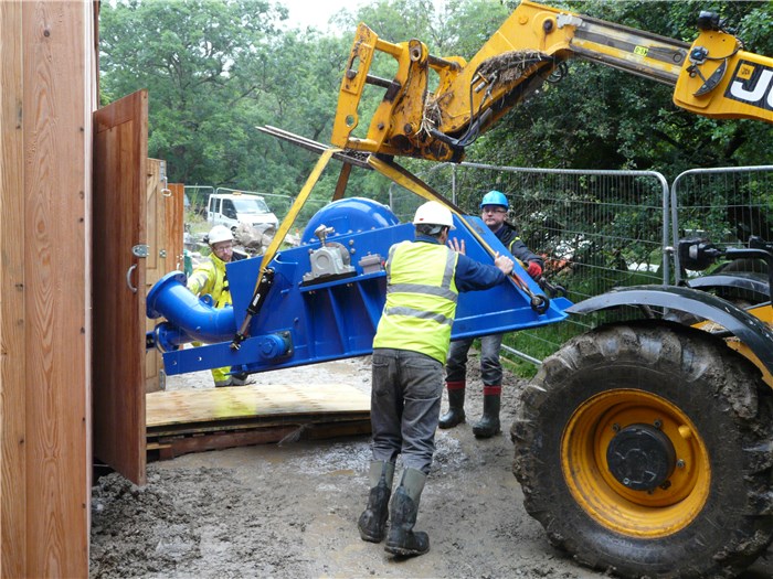 The turbine is manoeuvred through the power house door 29 July 2015